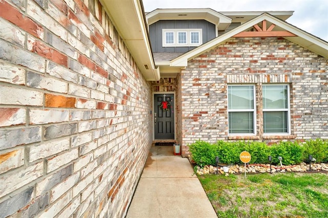 entrance to property featuring board and batten siding and brick siding
