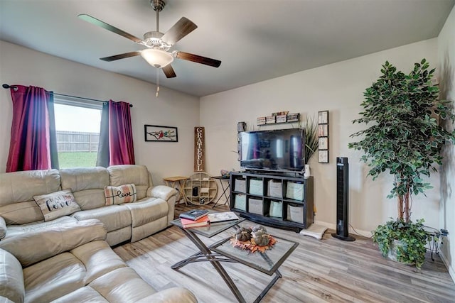 living room with light wood-style floors, baseboards, and ceiling fan