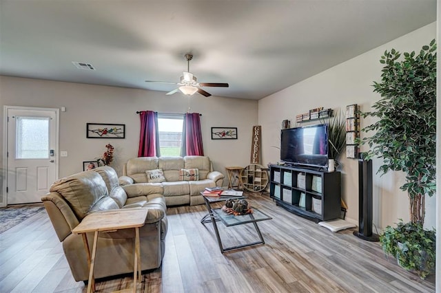 living area featuring a ceiling fan, visible vents, plenty of natural light, and light wood finished floors