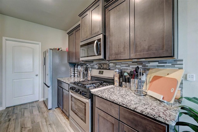 kitchen with tasteful backsplash, dark brown cabinetry, stainless steel appliances, and light wood-style flooring