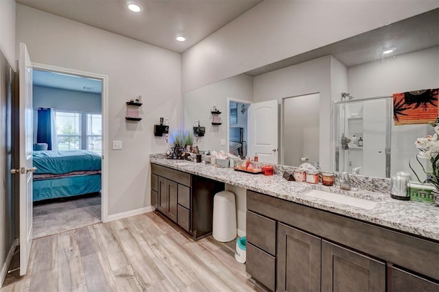 bathroom with vanity, a stall shower, connected bathroom, and wood finished floors