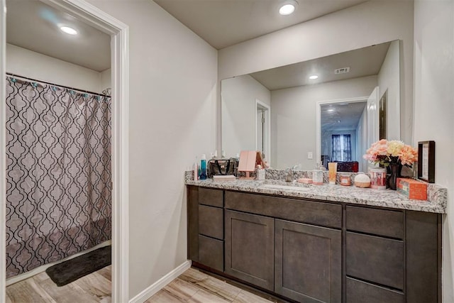full bathroom with vanity, visible vents, wood finished floors, baseboards, and a shower with shower curtain