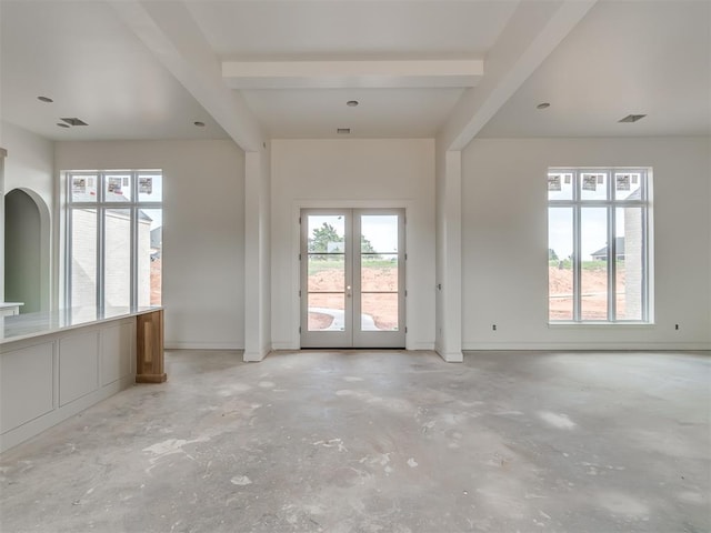 interior space with unfinished concrete floors, visible vents, beam ceiling, and french doors