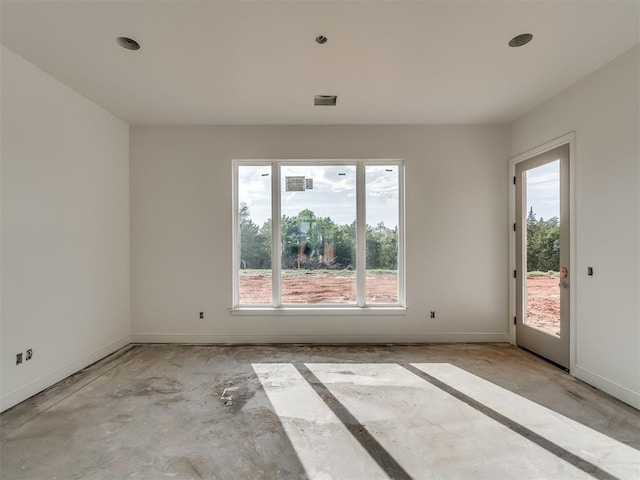 spare room featuring recessed lighting and baseboards