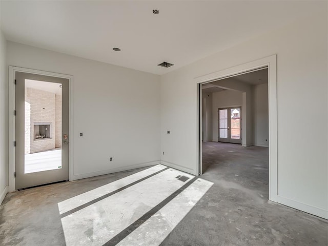 spare room featuring baseboards, visible vents, and unfinished concrete flooring