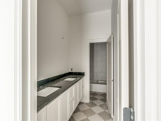 bathroom featuring tile patterned floors, a tub, and a sink