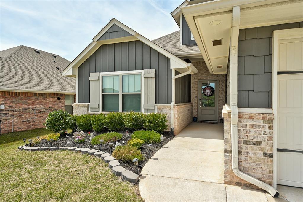 5301 Lannister Ln, Arcadia, OK 73007 - property entrance with board and batten siding, a shingled roof, and a yard