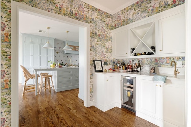 bar with indoor wet bar, dark wood-style flooring, wine cooler, and wallpapered walls