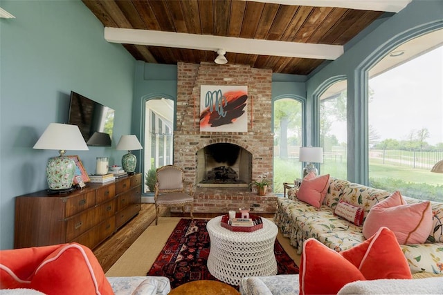 living room with wood ceiling, a brick fireplace, wood finished floors, and beam ceiling