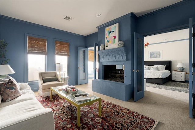 carpeted living area with crown molding, a multi sided fireplace, and visible vents