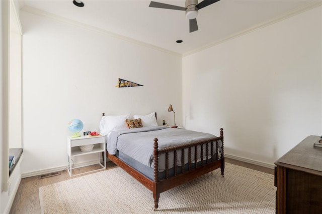 bedroom with baseboards, ornamental molding, ceiling fan, and wood finished floors