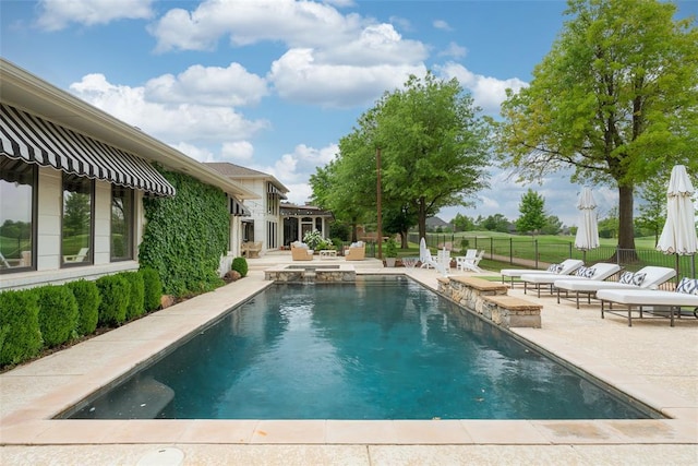 view of swimming pool featuring fence, a patio, and a pool with connected hot tub