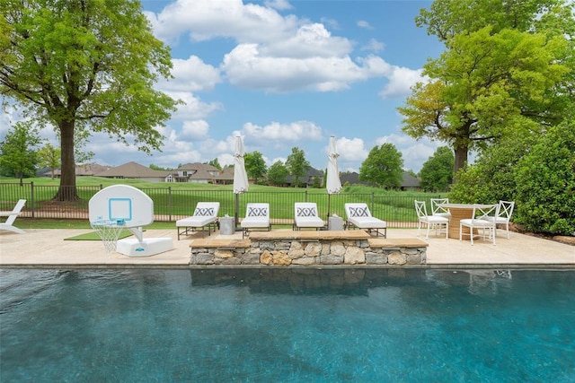 view of swimming pool featuring a patio, fence, and a fenced in pool