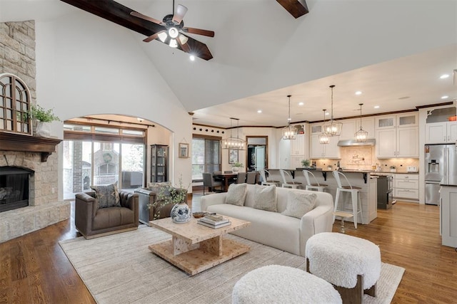 4301 Frisco Bridge Blvd, Edmond, OK 73034 - living room featuring high vaulted ceiling, recessed lighting, a ceiling fan, a chandelier, and a stone fireplace