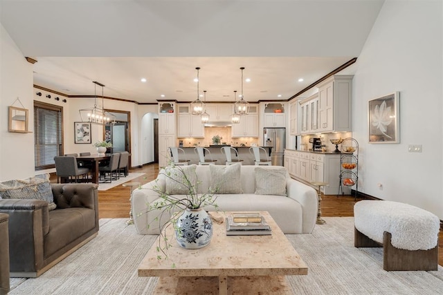 4301 Frisco Bridge Blvd, Edmond, OK 73034 - living room with a chandelier, light wood-style floors, arched walkways, and recessed lighting