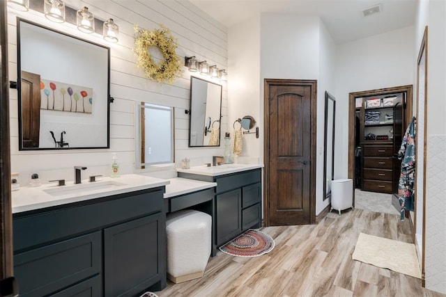 4301 Frisco Bridge Blvd, Edmond, OK 73034 - full bathroom featuring wood finished floors, two vanities, wood walls, and a walk in closet