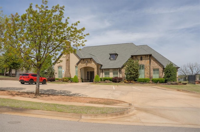 4301 Frisco Bridge Blvd, Edmond, OK 73034 - french country style house featuring stone siding and uncovered parking
