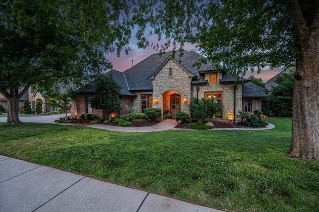 4400 The Ranch Rd, Edmond, OK 73034 - french country style house featuring a lawn, stone siding, and a shingled roof
