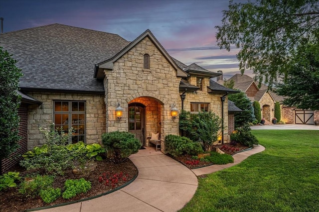 4400 The Ranch Rd, Edmond, OK 73034 - french country home with roof with shingles, a front yard, and stone siding