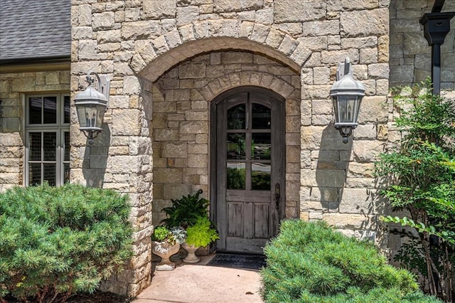 4400 The Ranch Rd, Edmond, OK 73034 - doorway to property featuring stone siding and roof with shingles