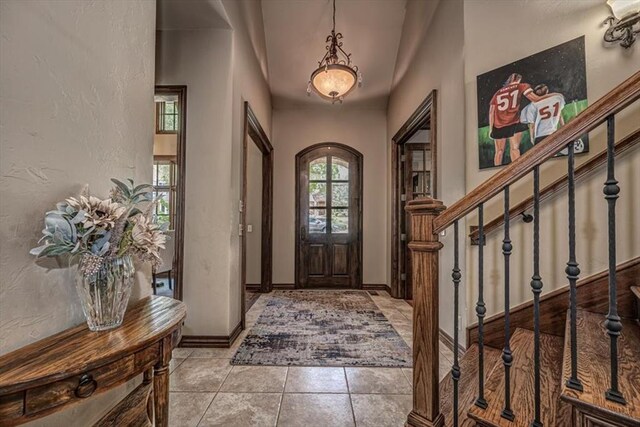 4400 The Ranch Rd, Edmond, OK 73034 - tiled entrance foyer with stairs, a textured wall, and baseboards