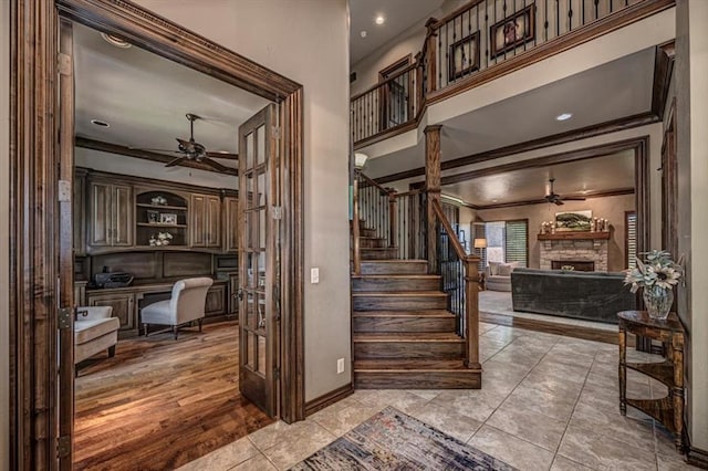 4400 The Ranch Rd, Edmond, OK 73034 - staircase featuring ornamental molding, ceiling fan, baseboards, and a fireplace