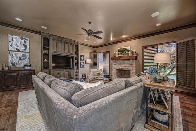 4400 The Ranch Rd, Edmond, OK 73034 - living room featuring a textured wall, ceiling fan, ornamental molding, wood finished floors, and a stone fireplace