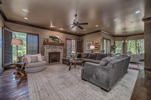 4400 The Ranch Rd, Edmond, OK 73034 - living area featuring a ceiling fan, a healthy amount of sunlight, crown molding, and a fireplace