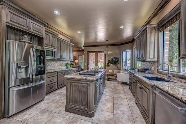 4400 The Ranch Rd, Edmond, OK 73034 - kitchen featuring appliances with stainless steel finishes, a healthy amount of sunlight, a kitchen island, and a sink