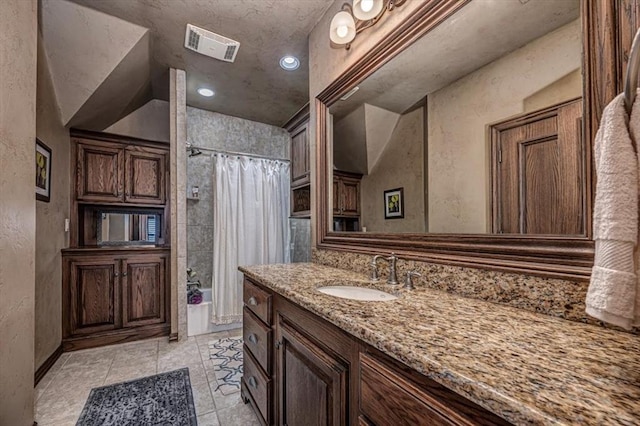 4400 The Ranch Rd, Edmond, OK 73034 - bathroom featuring a textured wall, visible vents, a shower with shower curtain, vanity, and tile patterned flooring
