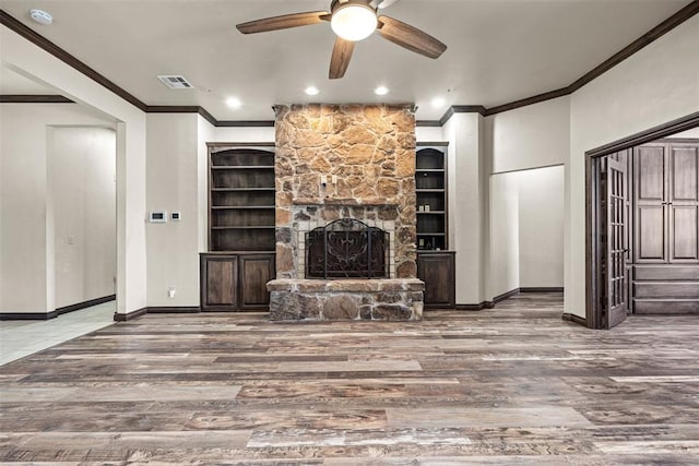 212 SW 144th, Oklahoma City, OK 73170 - unfurnished living room with crown molding, wood finished floors, a ceiling fan, baseboards, and a stone fireplace