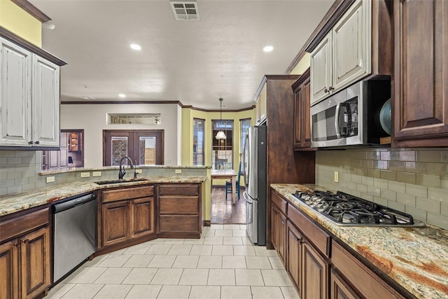 212 SW 144th, Oklahoma City, OK 73170 - kitchen featuring appliances with stainless steel finishes, a sink, light tile patterned floors, decorative backsplash, and crown molding