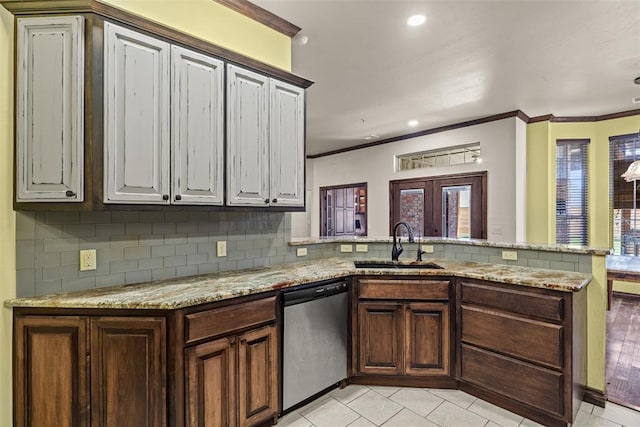 212 SW 144th, Oklahoma City, OK 73170 - kitchen with dishwasher, a sink, a peninsula, decorative backsplash, and ornamental molding
