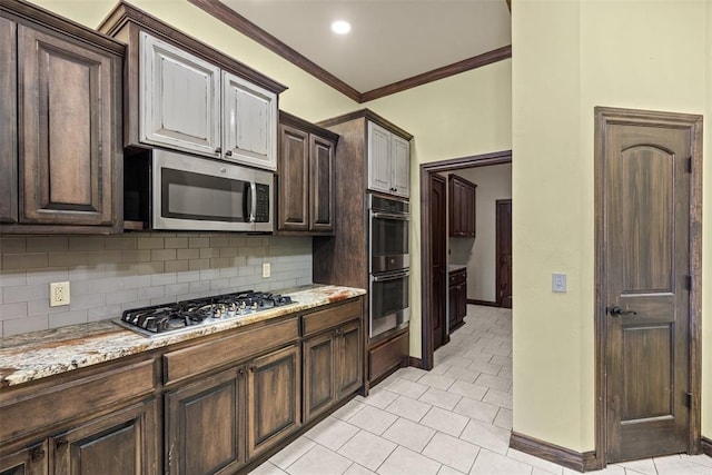 212 SW 144th, Oklahoma City, OK 73170 - kitchen with stainless steel appliances, backsplash, dark brown cabinets, baseboards, and light tile patterned flooring