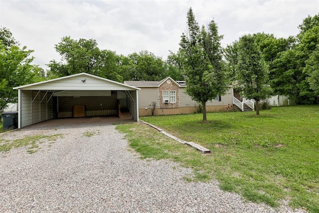 ranch-style home featuring a detached carport, fence, driveway, and a front yard