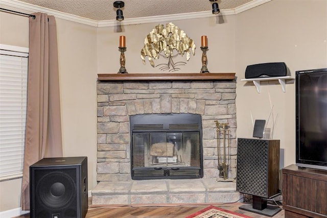 details with a textured ceiling, ornamental molding, a fireplace, and wood finished floors