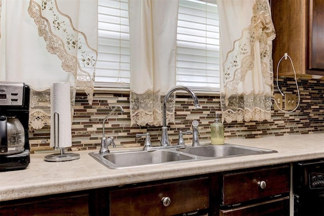 kitchen with a sink, decorative backsplash, dark brown cabinetry, and light countertops