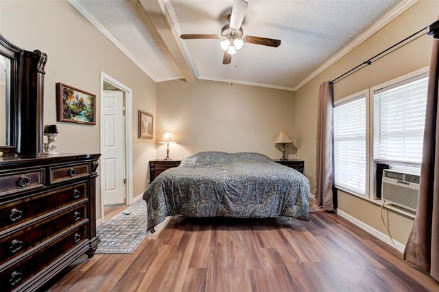 bedroom with crown molding, baseboards, wood finished floors, and multiple windows