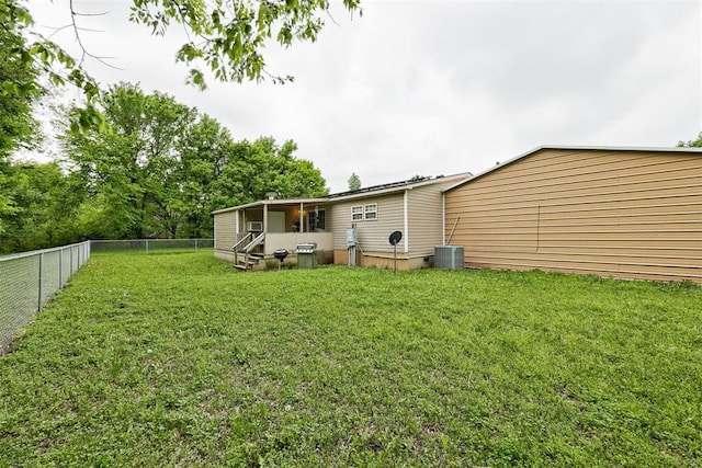 view of yard featuring entry steps, central AC unit, and a fenced backyard