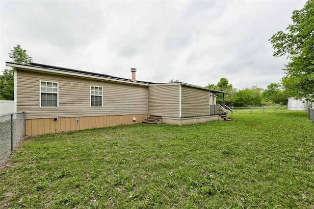 back of house with a lawn, a fenced backyard, and entry steps
