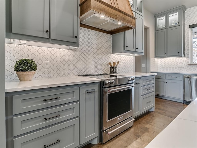 3345 Red Ridge Dr, Blanchard, OK 73010 - kitchen with stainless steel appliances, custom exhaust hood, gray cabinetry, and backsplash
