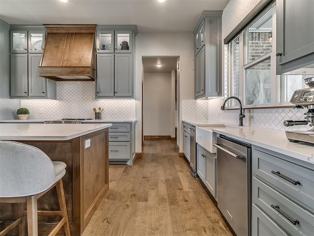 3345 Red Ridge Dr, Blanchard, OK 73010 - kitchen with custom range hood, gray cabinetry, stainless steel dishwasher, a sink, and light wood-style floors