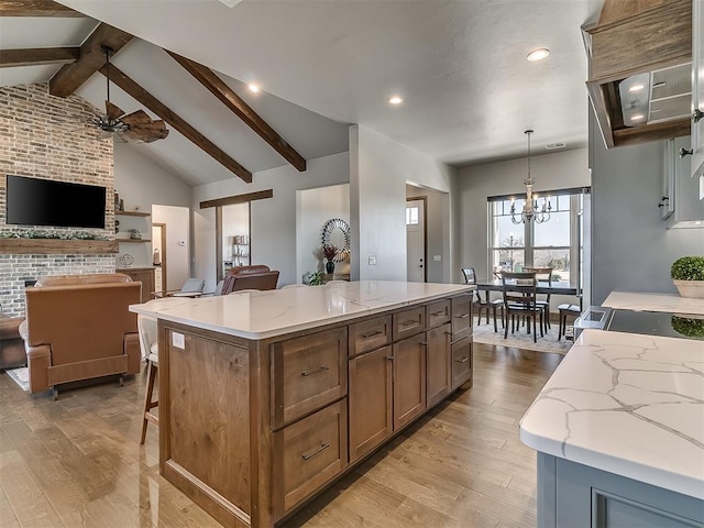 3345 Red Ridge Dr, Blanchard, OK 73010 - kitchen with open floor plan, a kitchen island, light stone counters, light wood-type flooring, and recessed lighting
