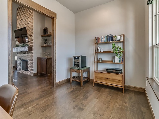 3345 Red Ridge Dr, Blanchard, OK 73010 - sitting room featuring wood finished floors, a brick fireplace, and baseboards