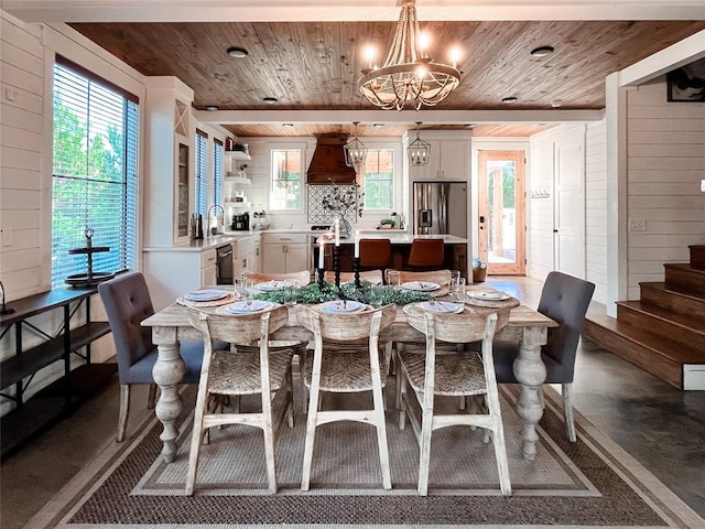 dining space featuring concrete floors, wood ceiling, a chandelier, and stairway