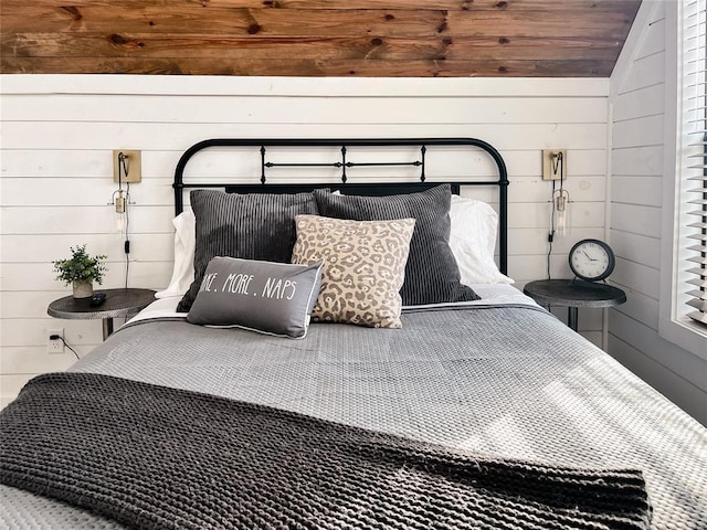 bedroom featuring wood walls and lofted ceiling