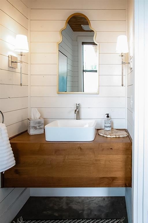 bathroom with wooden walls and a sink