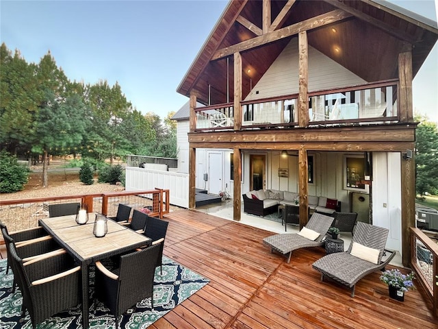 rear view of property with outdoor dining space, a balcony, an outdoor hangout area, and a deck