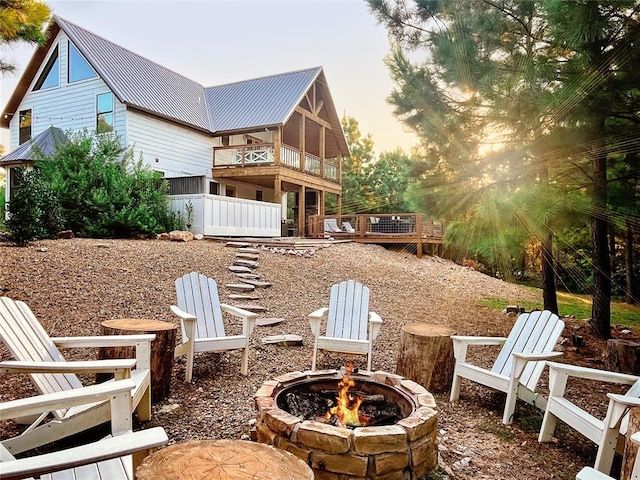 exterior space with a fire pit and a balcony