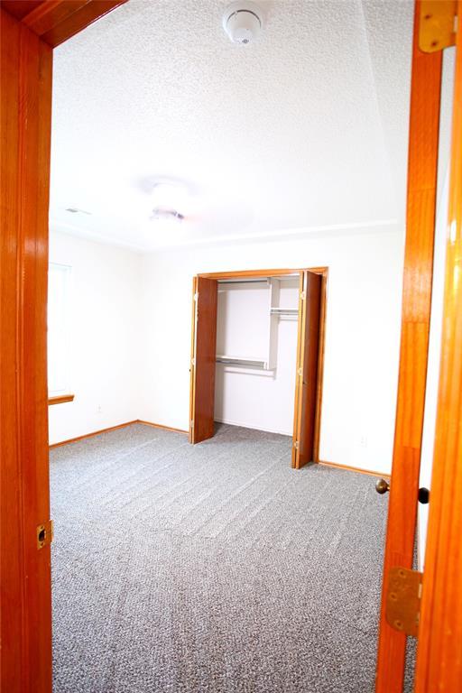 5112 SE 85th St, Oklahoma City, OK 73135 - unfurnished bedroom featuring carpet, a textured ceiling, and baseboards